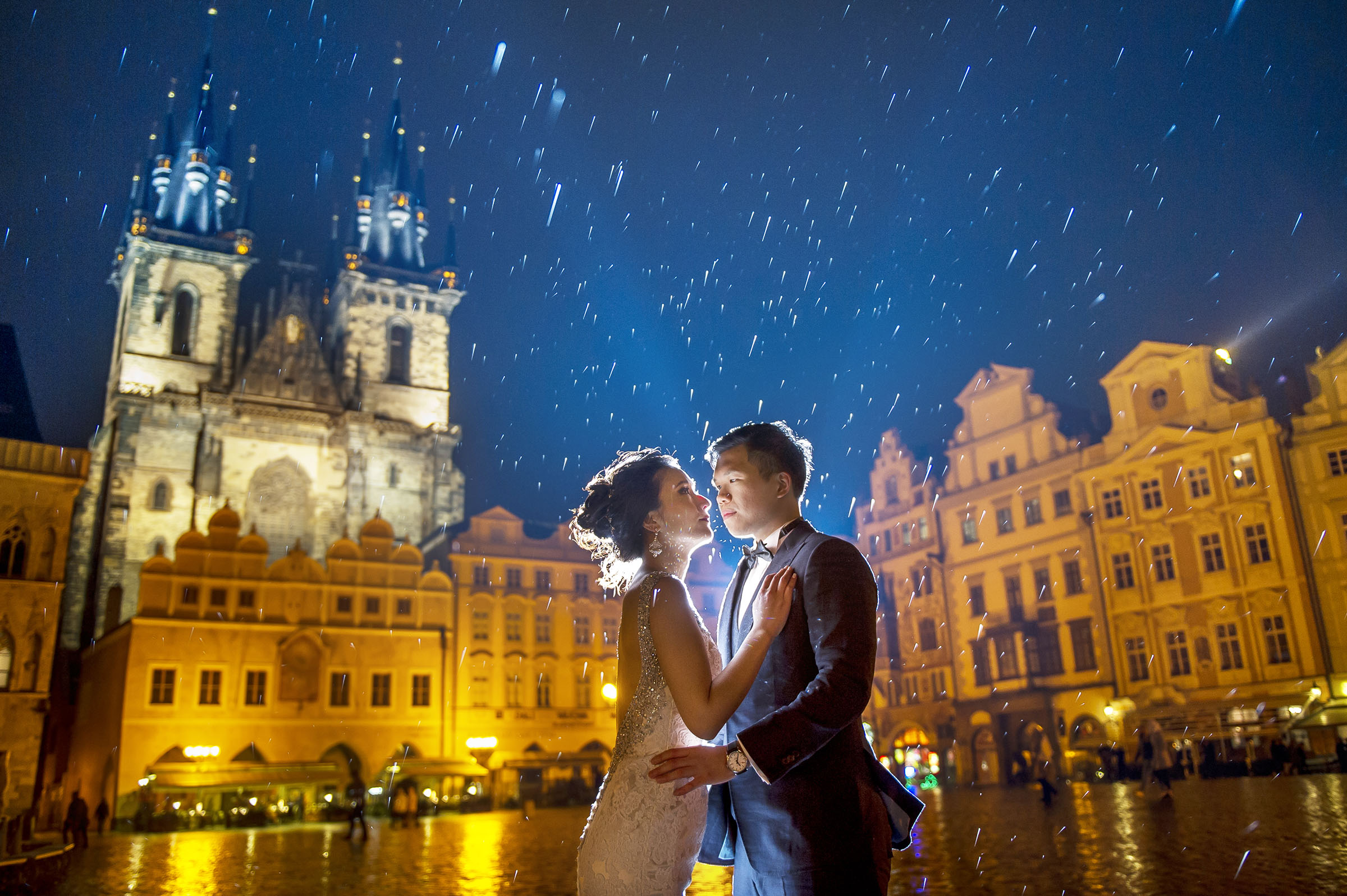 Epic blue hour pre-wedding photoshoot in Prague – Taiwanese couple in the rain at Old Town Square with cinematic lighting.